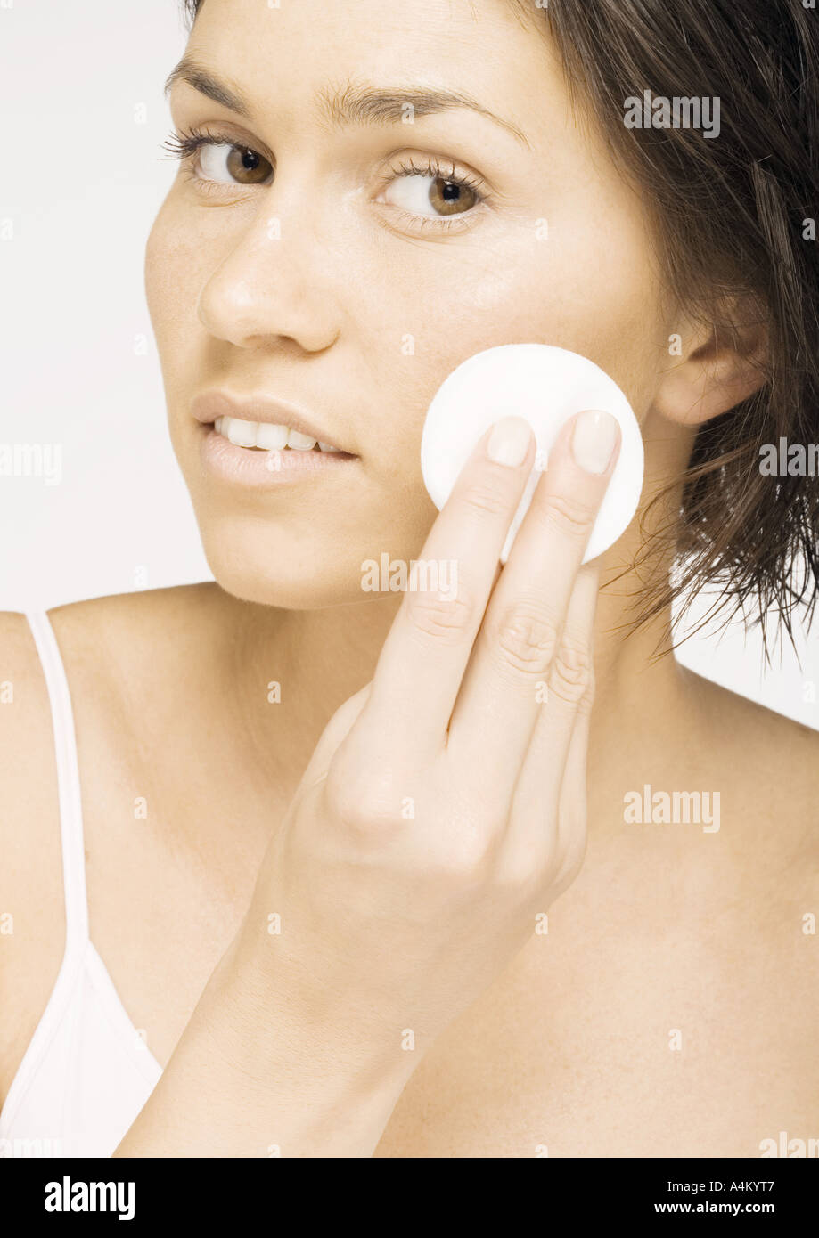 Woman using cotton pad on face Stock Photo