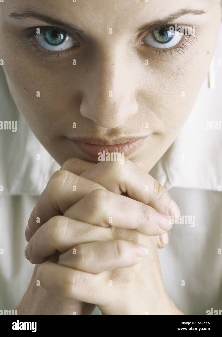 Woman with hands clasped under chin, portrait Stock Photo