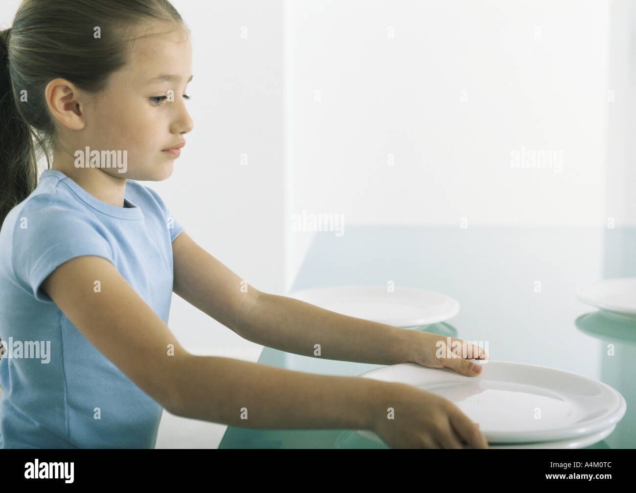 Girl setting plates on table Stock Photo Alamy