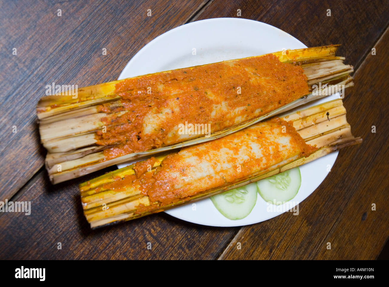 Traditional Perenakan nyonya fish cakes called otak otak wrapped in banana leaves and cooked in bamboo Stock Photo