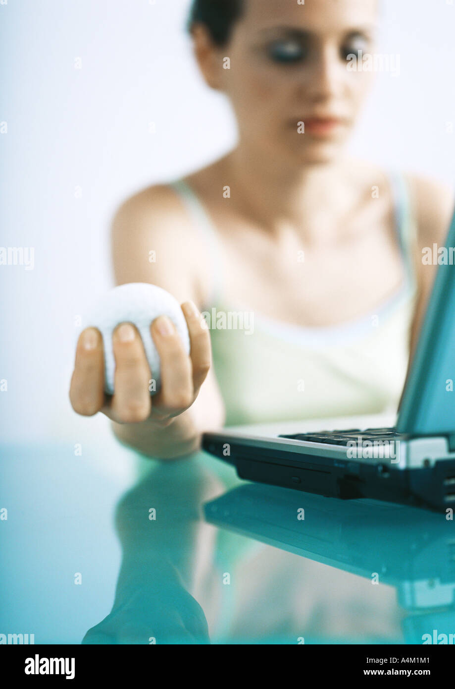 Woman holding stress ball, eyes closed Stock Photo