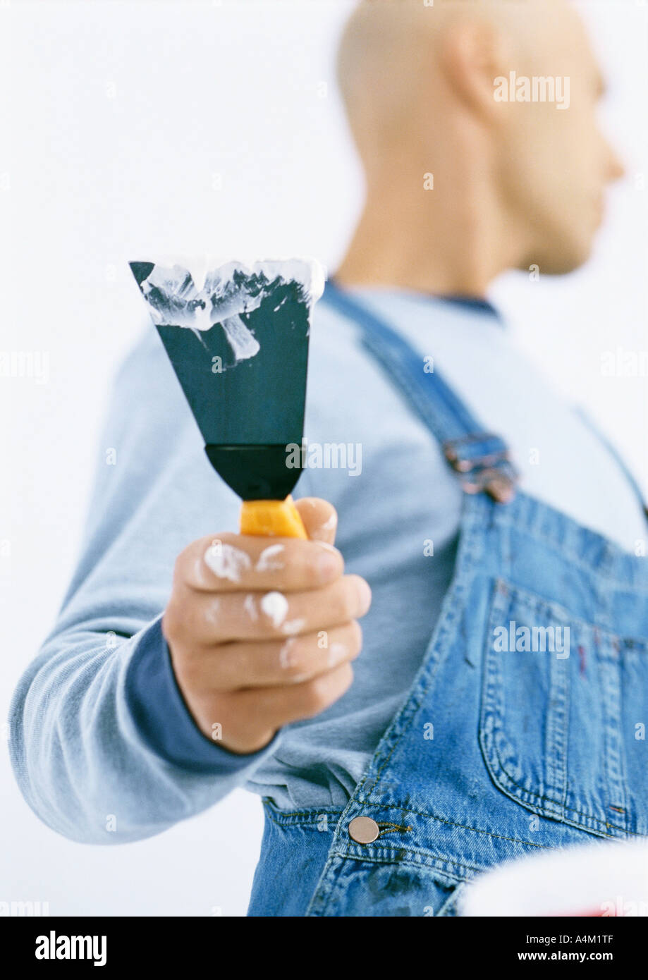 Man holding putty knife, low angle view Stock Photo