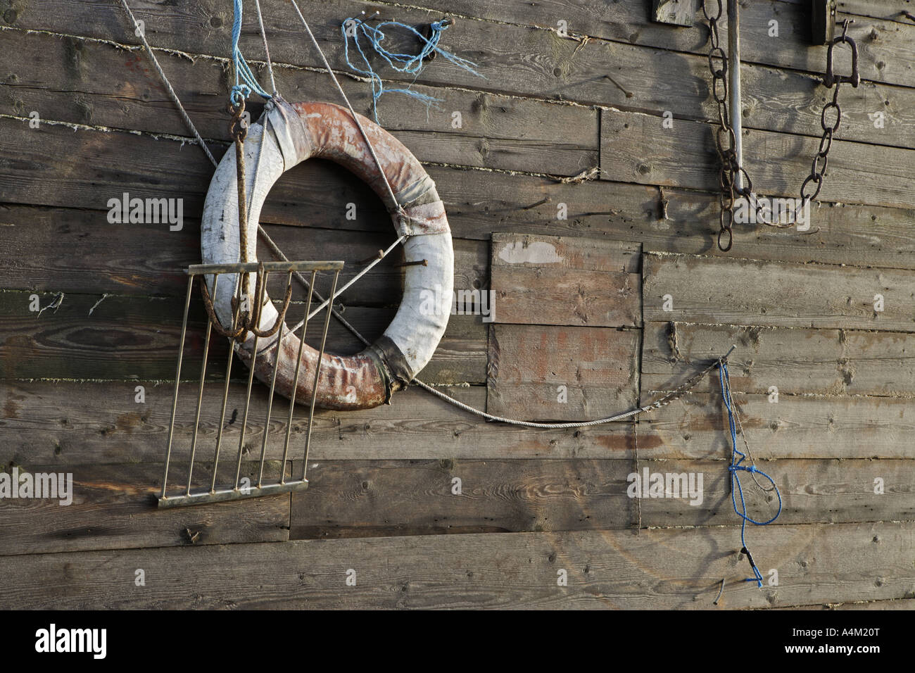 Parts of old fishing gear hanging on the wall of a boathouse Stock Photo -  Alamy