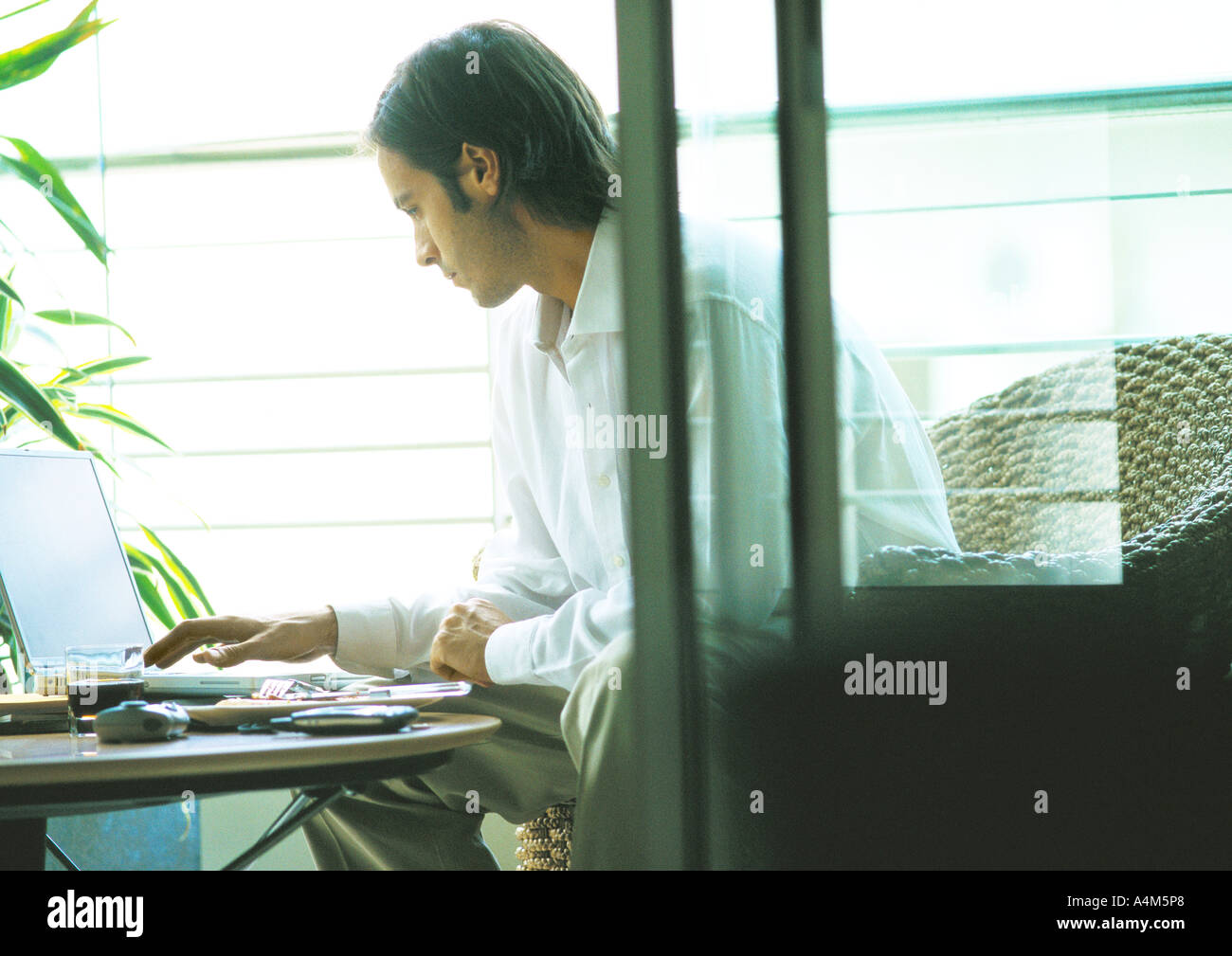 Man using laptop on terrace Stock Photo