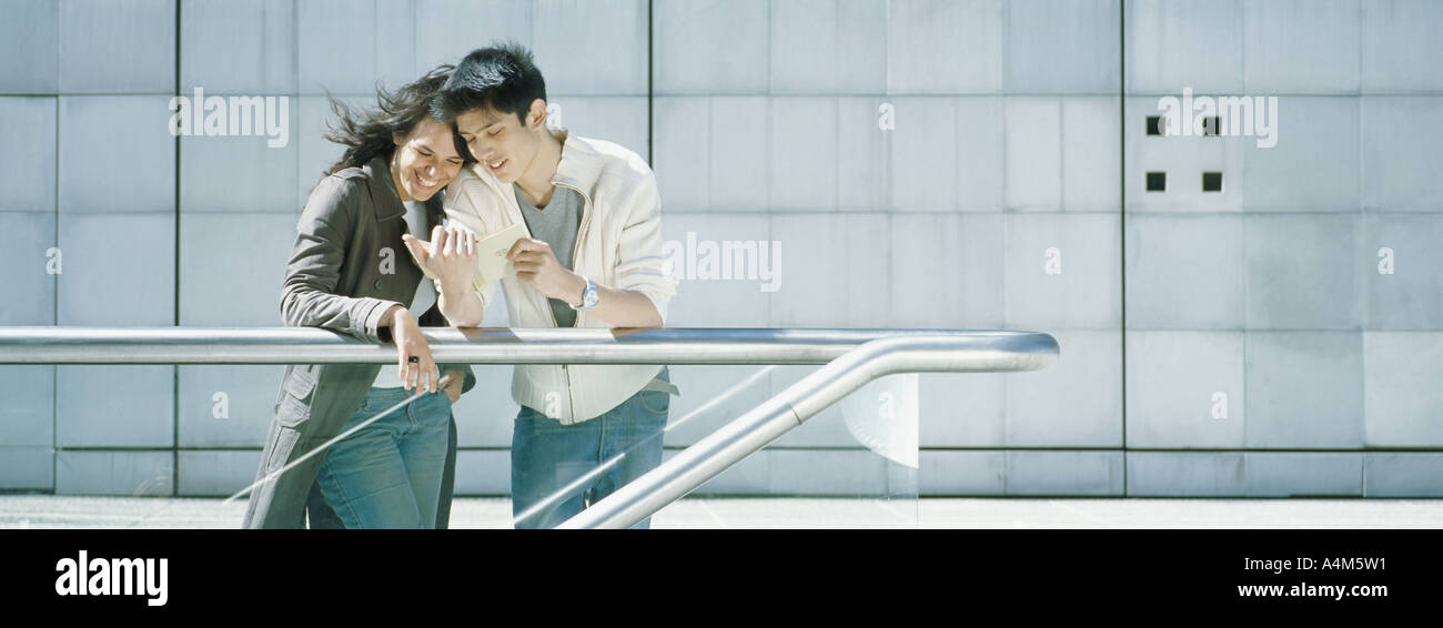 Young couple leaning against rail Stock Photo