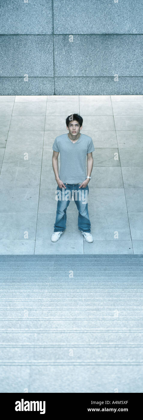 Young man standing at bottom of steps Stock Photo