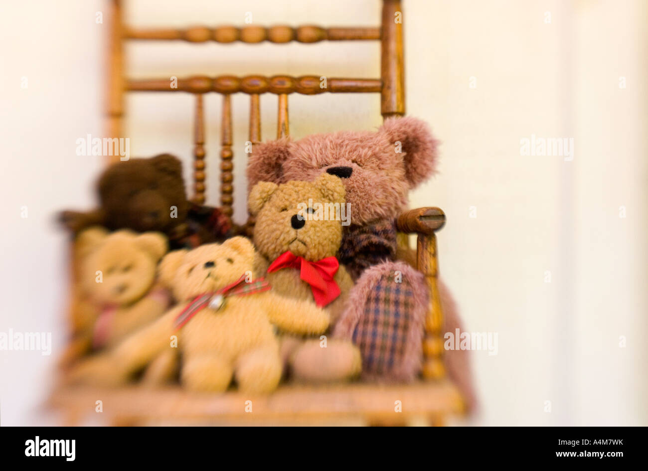 A group of classic teddy bears displayed in an antique high chair Stock