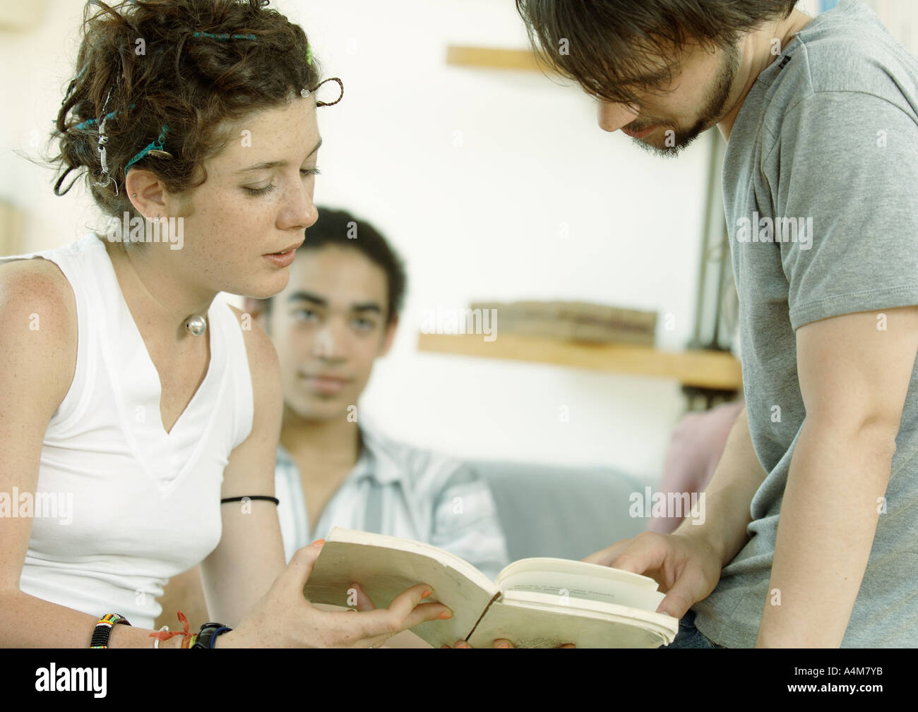 Young people looking at book together Stock Photo