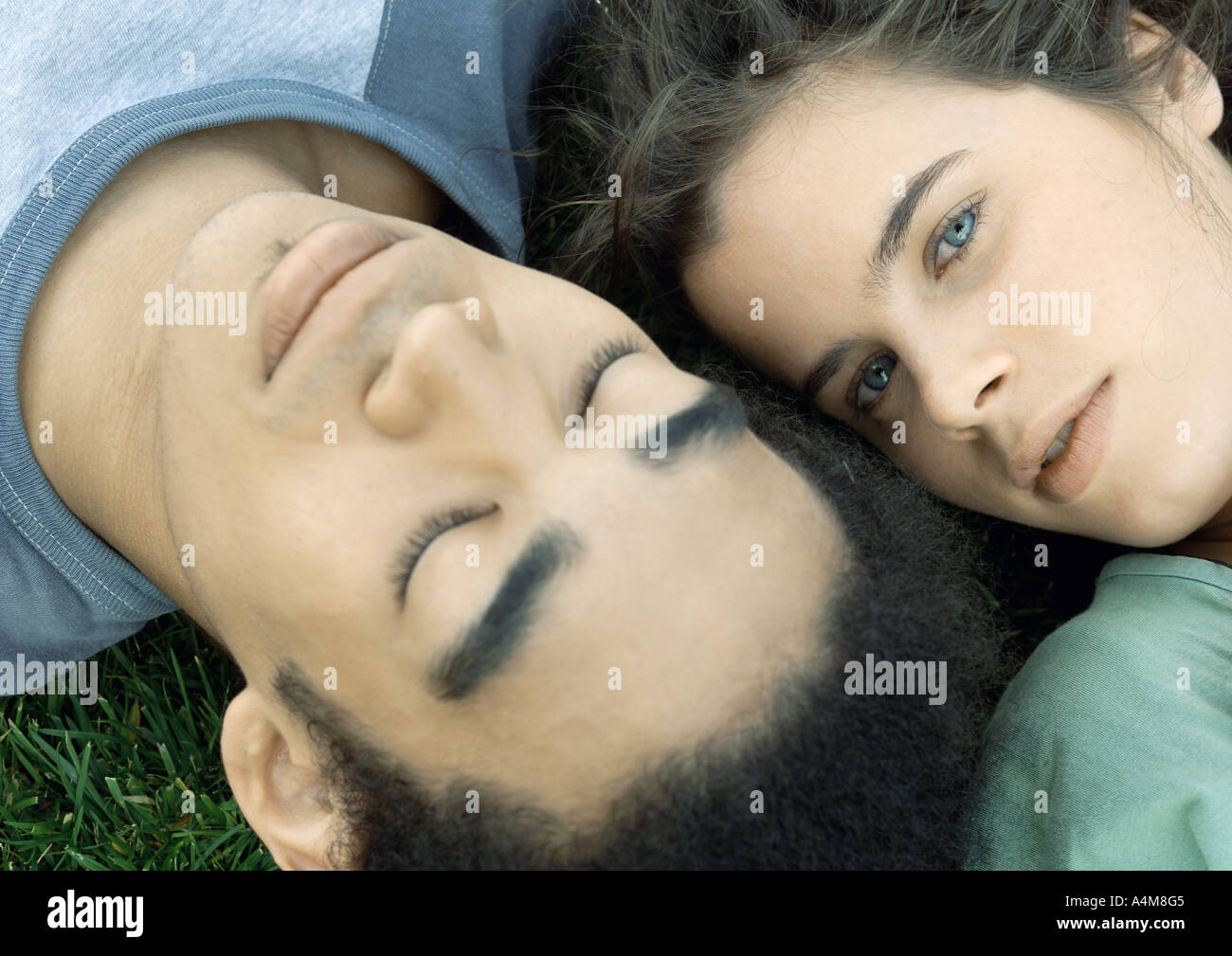 Young couple lying on grass together, close-up Stock Photo