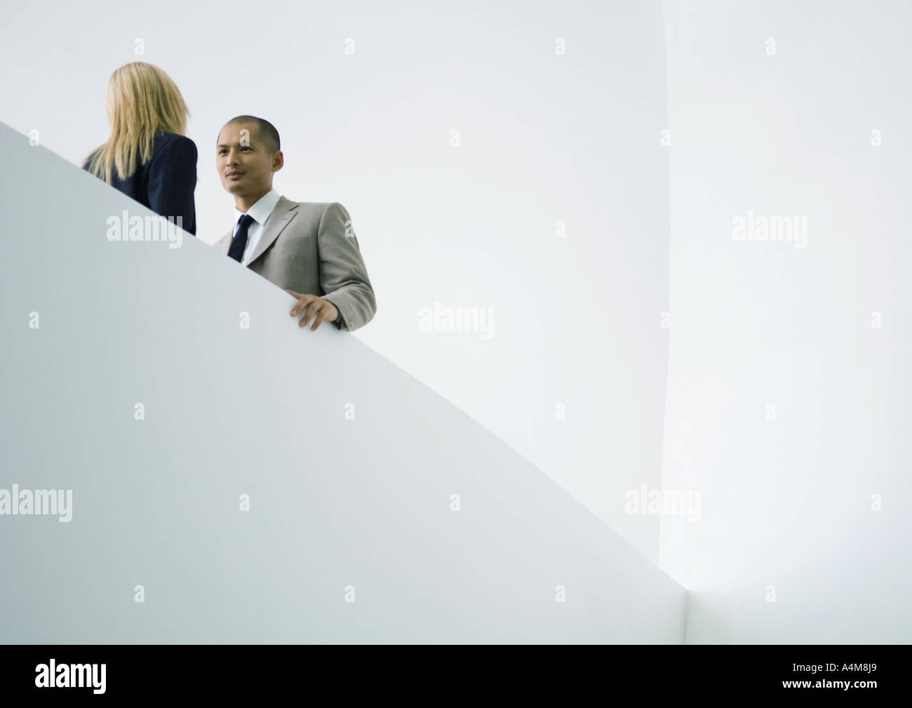 Businessman and businesswoman standing face to face, low angle view Stock Photo
