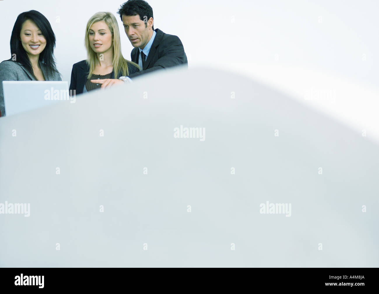 Business team looking at laptop computer together Stock Photo