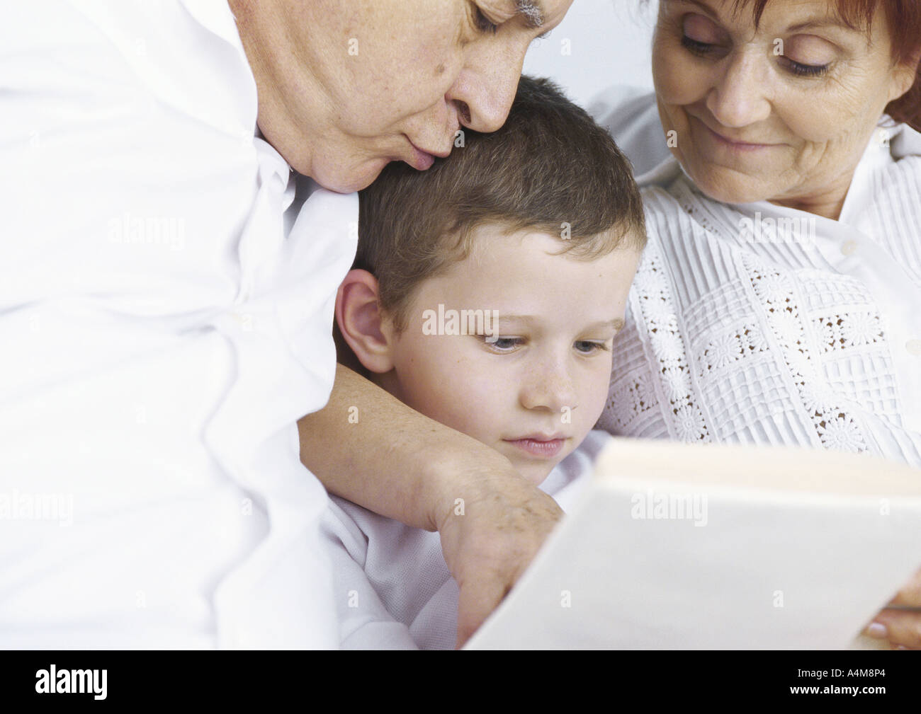 Grandparents reading with grandson Stock Photo Alamy