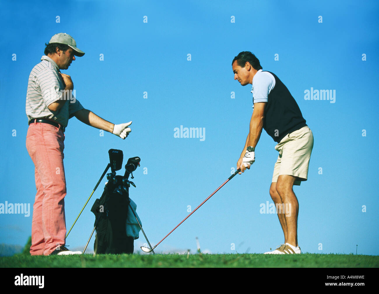 Man taking lessons with golf instructor Stock Photo