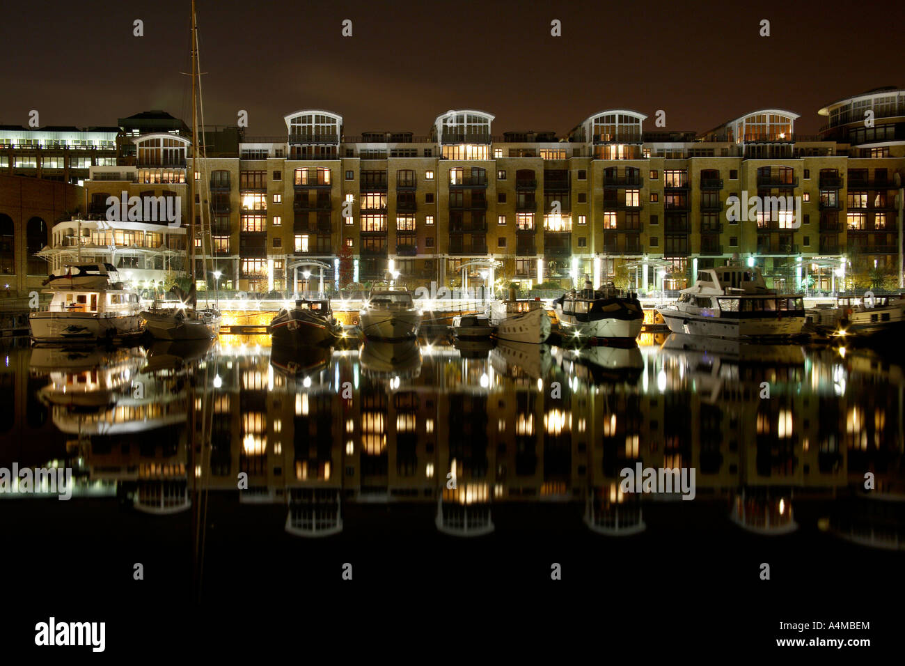 Luxury apartments and boats in St Katherine's Docks at night. Tower