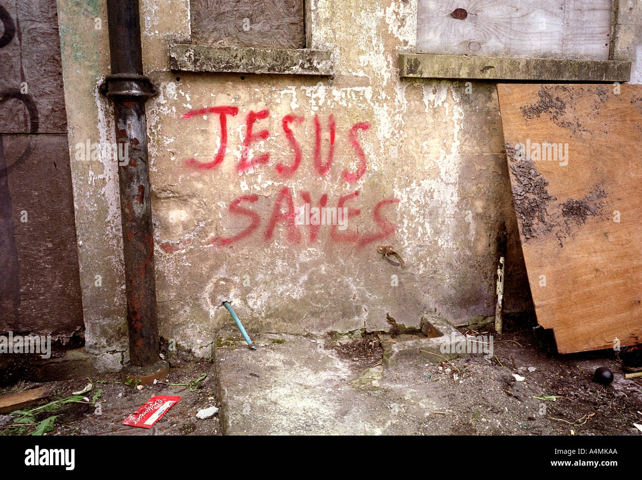 JESUS SAVES; red painted graffiti on wall of derelict house Stock Photo