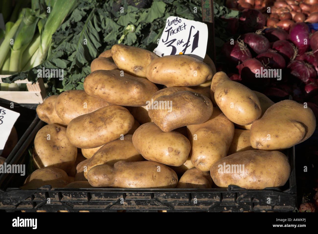 Large potatoes  and other vegetables on display in a market stall 2007 Stock Photo
