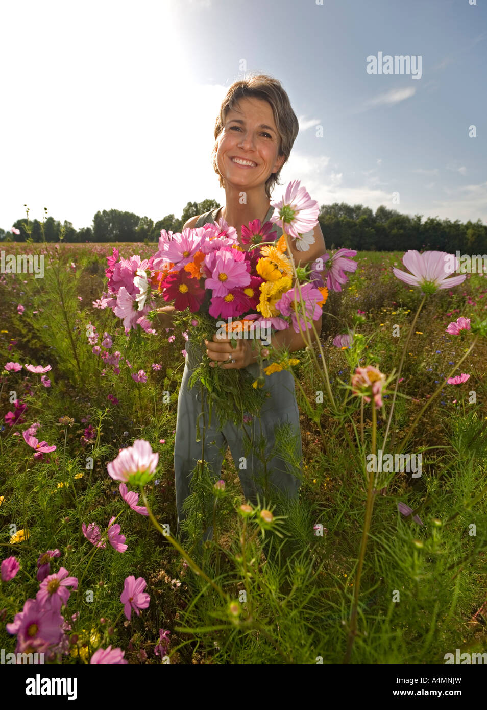 A smiling young Lady holding a bunch of flowers (France). Souriante jeune femme  tenant un bouquet de fleurs (France). Stock Photo