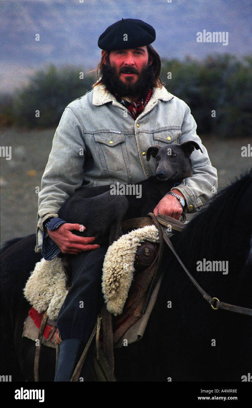 A tourist s guide gaucho on horseback with his dog in El Calafate Argentina Stock Photo