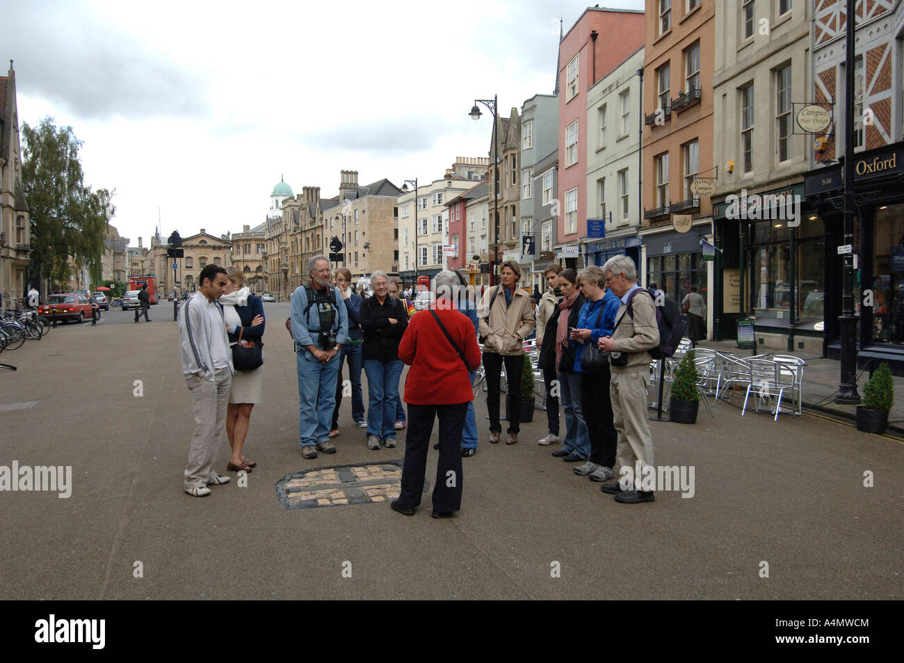 A tour guide in Broad st Oxford,near the mark on the road that marks the spot of the martyrdom of three religious leaders Stock Photo