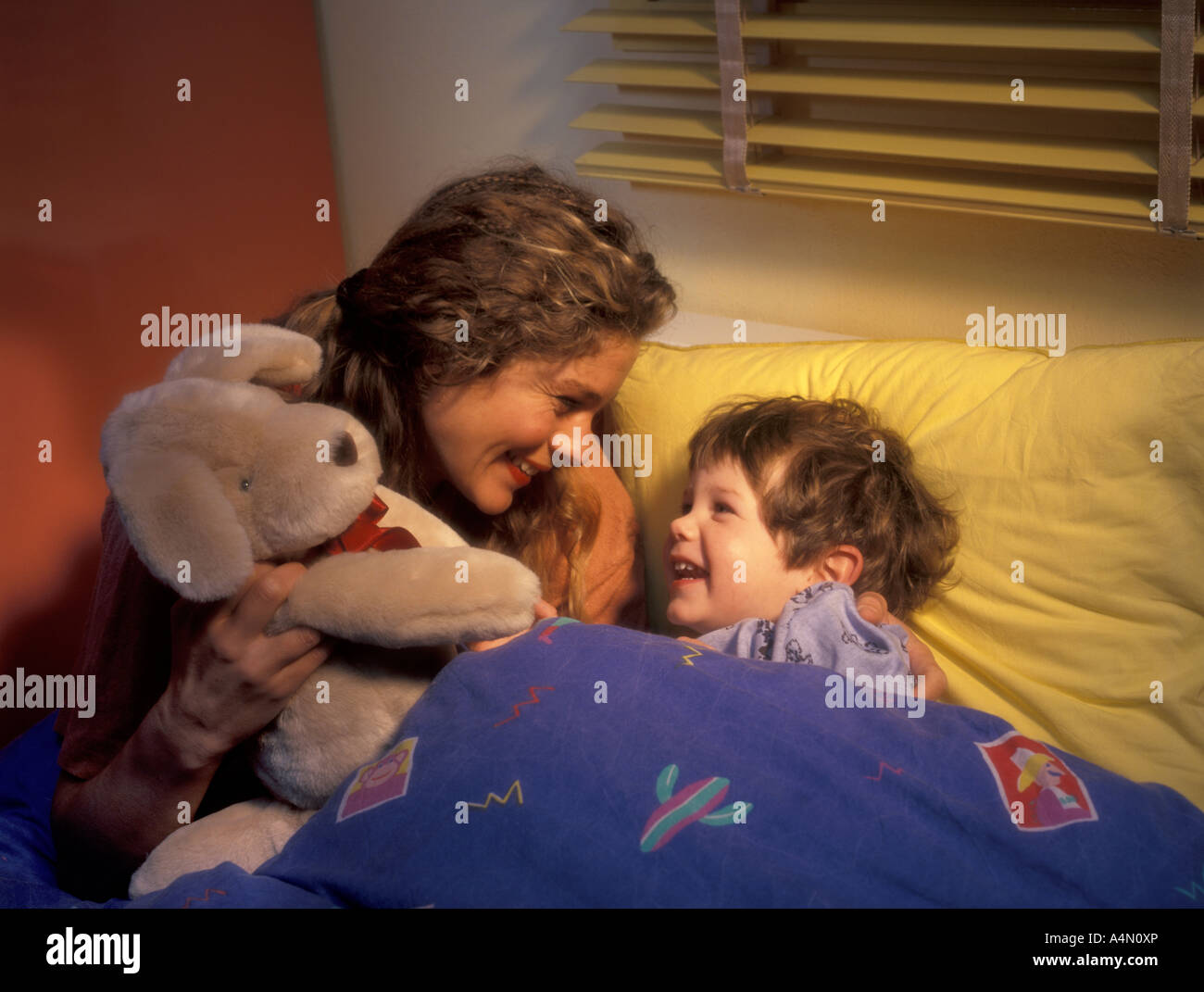 Mother puts son to bed Stock Photo Alamy