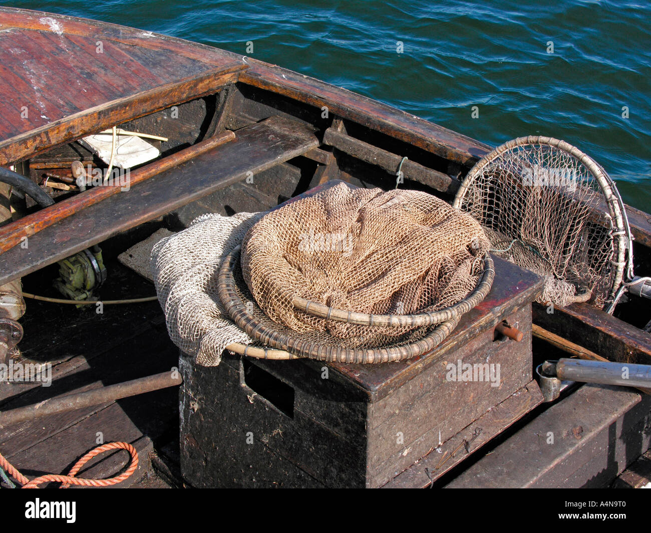 old wooden fishing boat with old nets and weirs Stock Photo