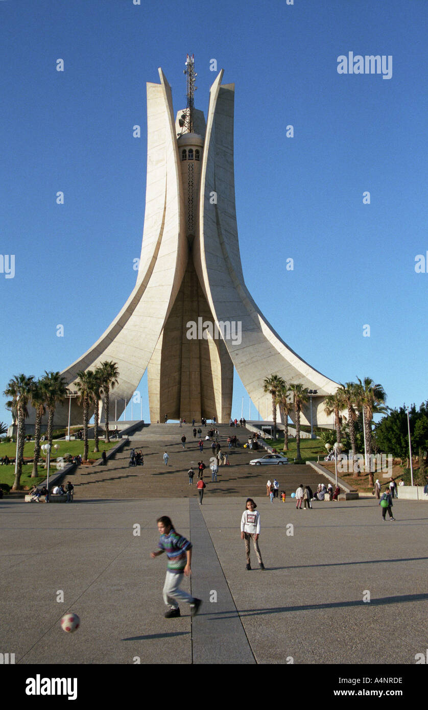 Kids play football in front of monument Ryad El Feth honouring  the Algeria War of Independence in Algiers, Algeria, 2001 Stock Photo