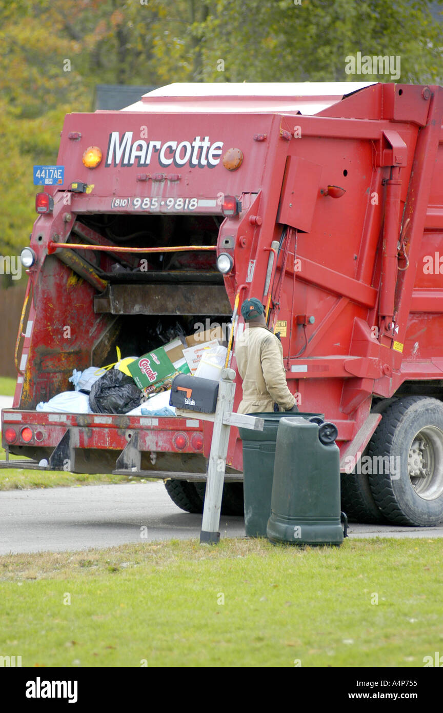 Garbage truck picks up trash in a residential neighborhood Stock Photo