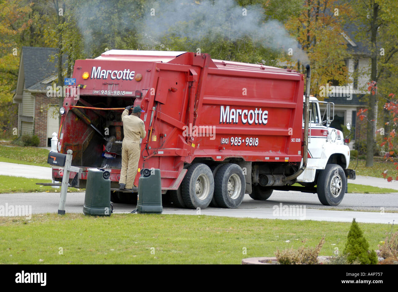 Garbage truck picks up trash in a residential neighborhood Stock Photo
