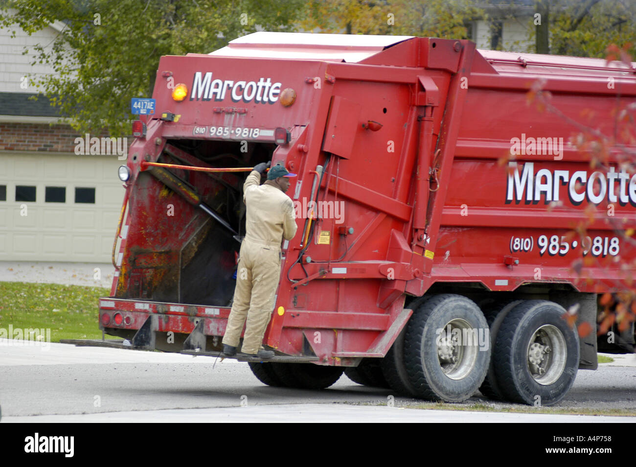 Garbage truck picks up trash in a residential neighborhood Stock Photo