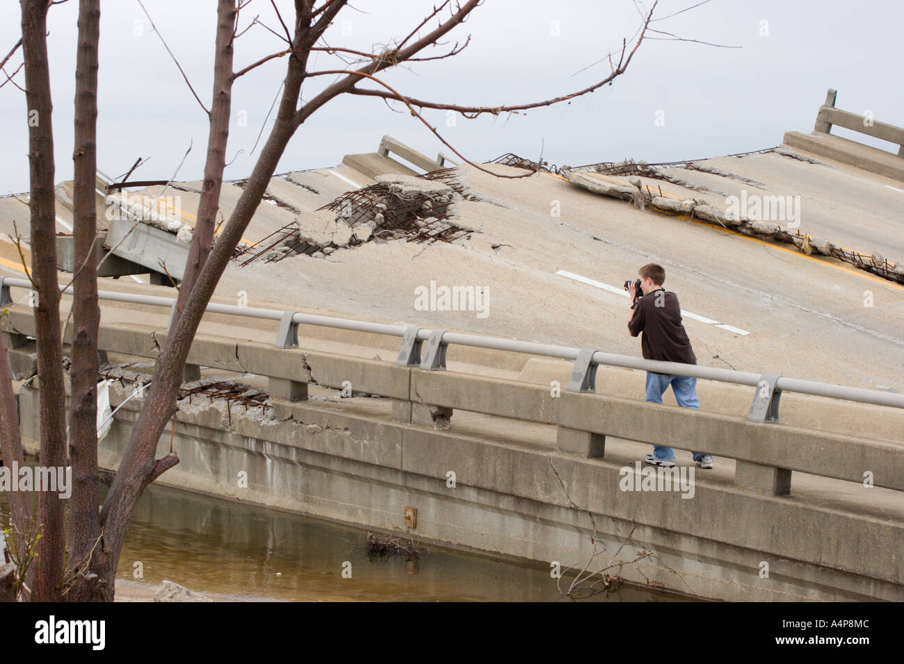 Male teen ager standing on remains of draw bridge connecting Ocean