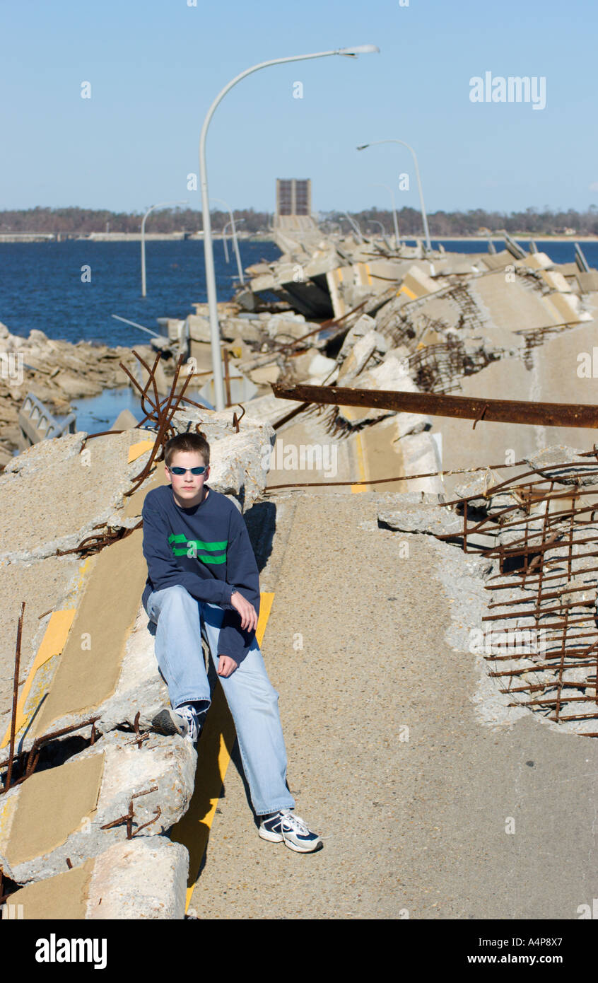 Male teenaged youth sitting on remains of Ocean Springs Bridge east of