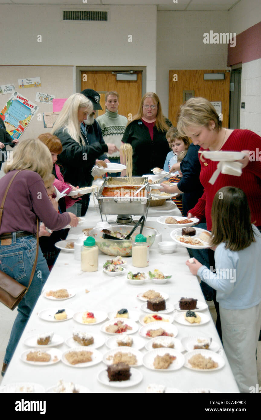 Families of elementary students gather in a school cafeteria for Christmas dinner Stock Photo