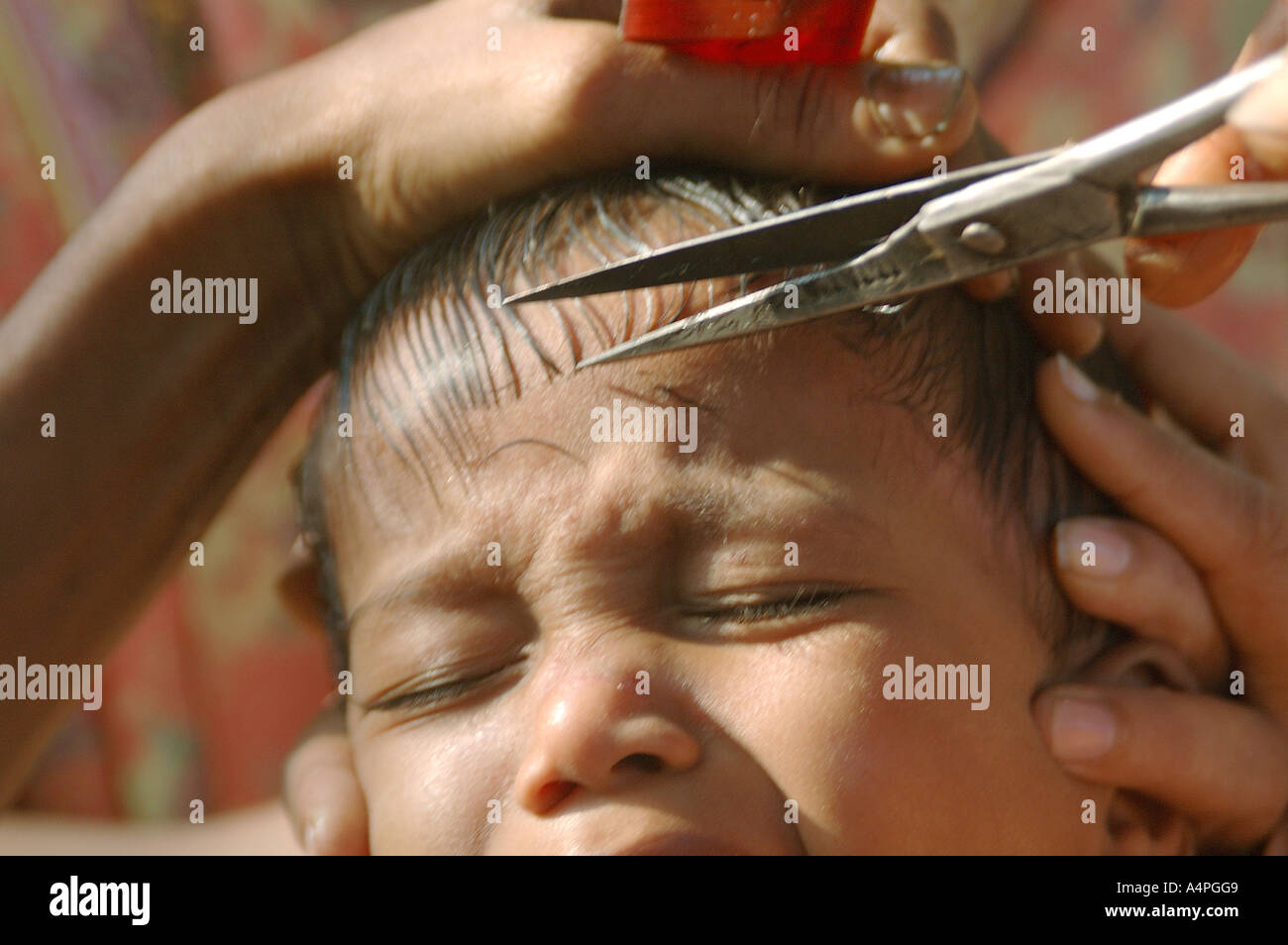 Ang77691 Indian Barber Cutting Hair Of A Small Child With Scissor Child Crying Forced To Cut Hair Model Release 468 Stock Photo Alamy
