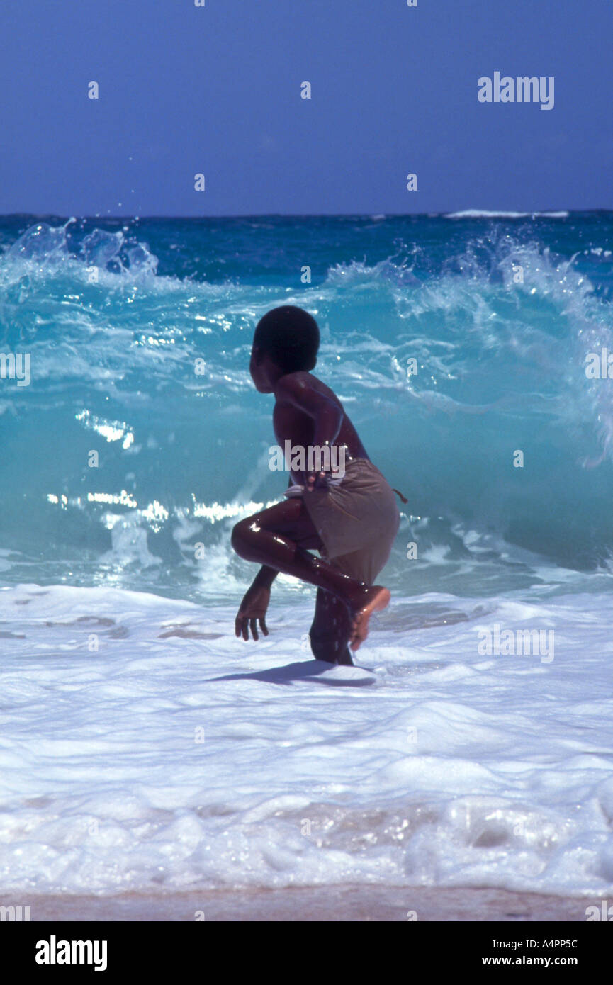 Boy standing in Atlantic Ocean waves Stock Photo