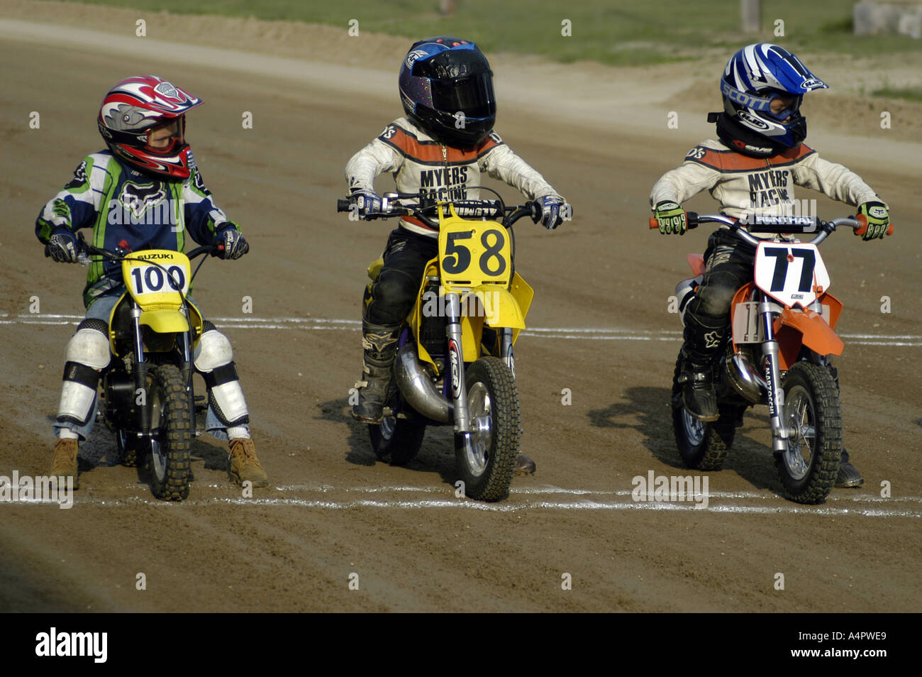 3 children on the starting line of dirt track motorcycle race Croswell