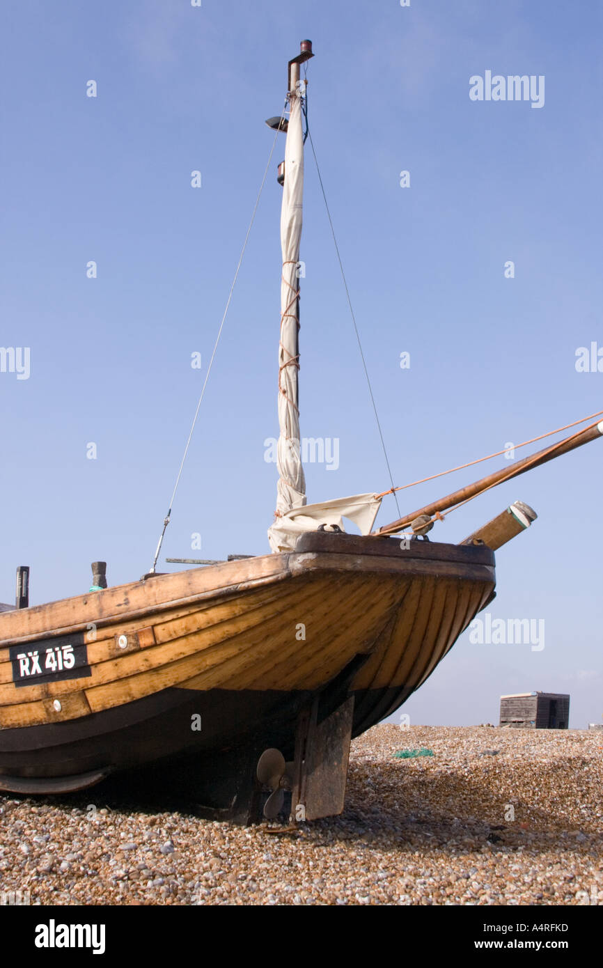 An old traditional wooden fishing boat on the shingle beach at ...