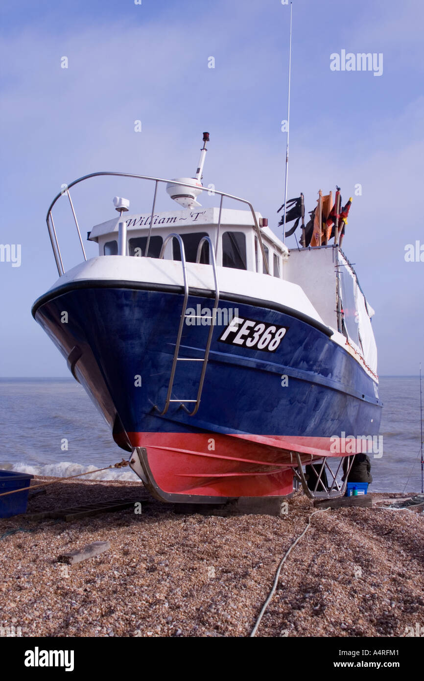 Red white and blue modern fishing boat at Dungeness. Note the skids and