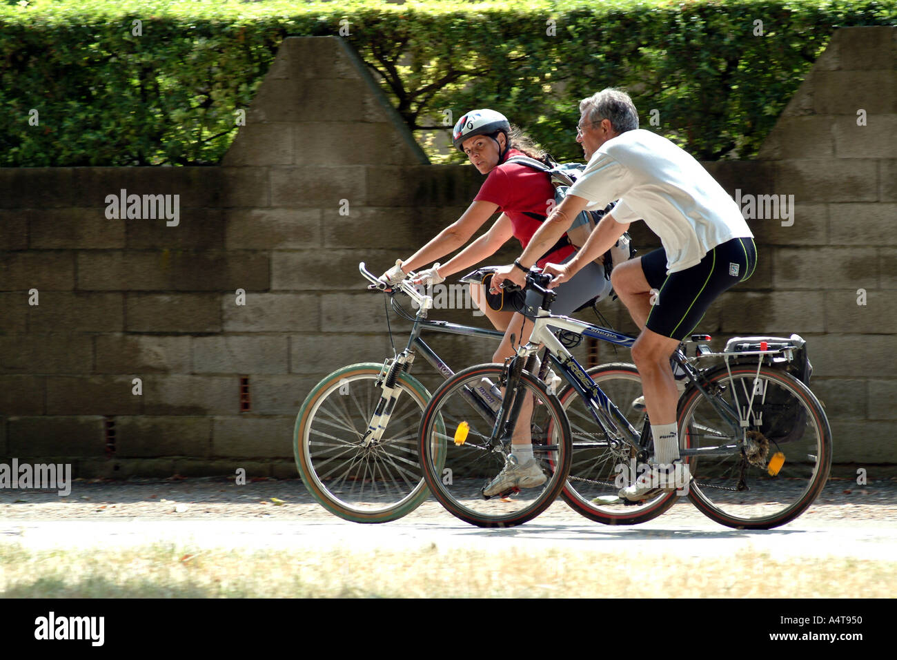 Couple cycling on towpath of Canal du Midi Southern France Stock Photo