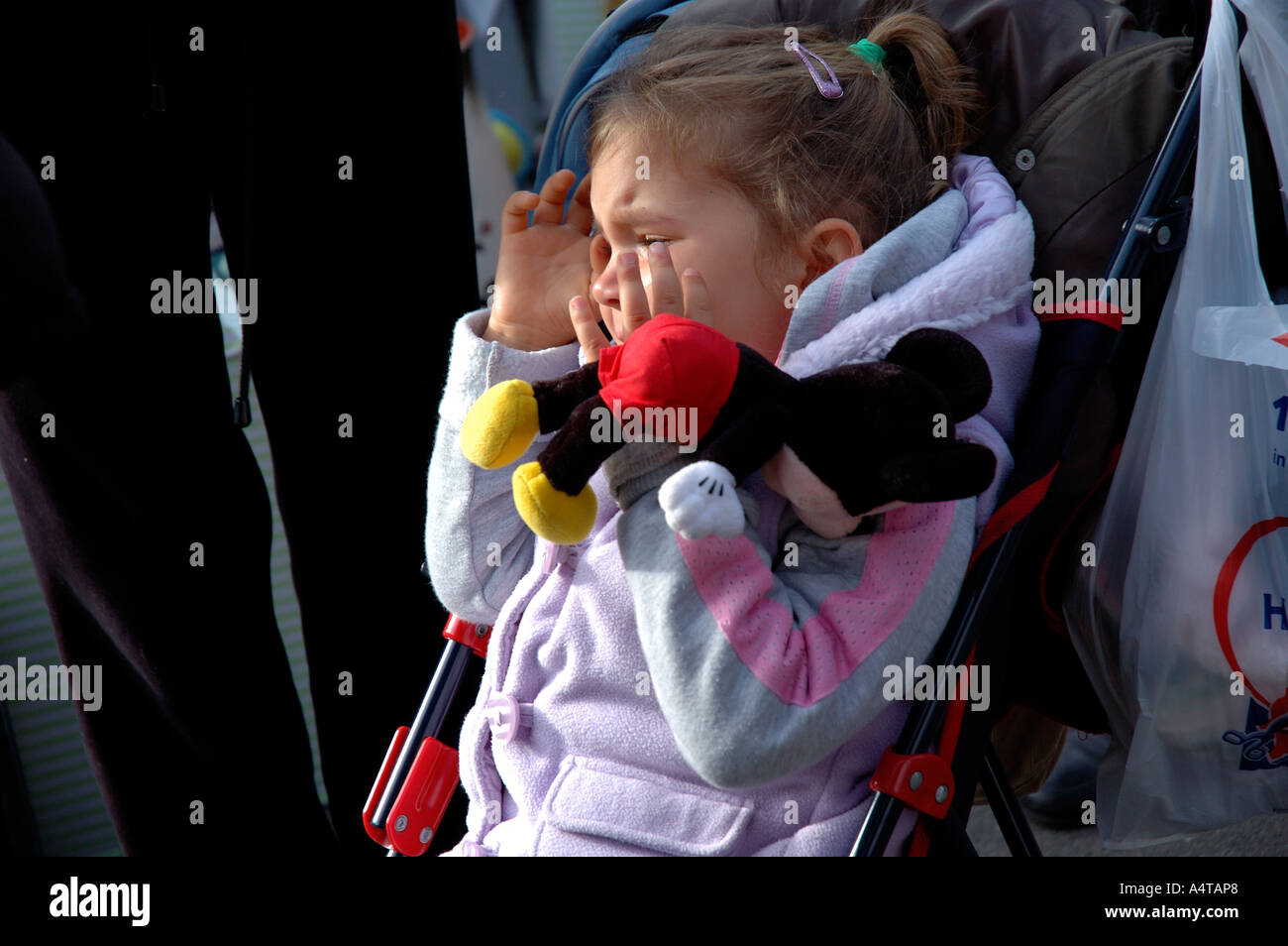 Child in tears in a pushchair. Stock Photo