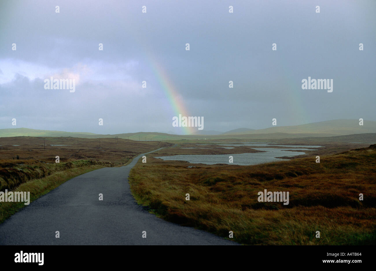 The Hebridean Island of North Uist in the Outer Hebrides, Scotland, UK. Rainbow over the road east to Malacleit Stock Photo