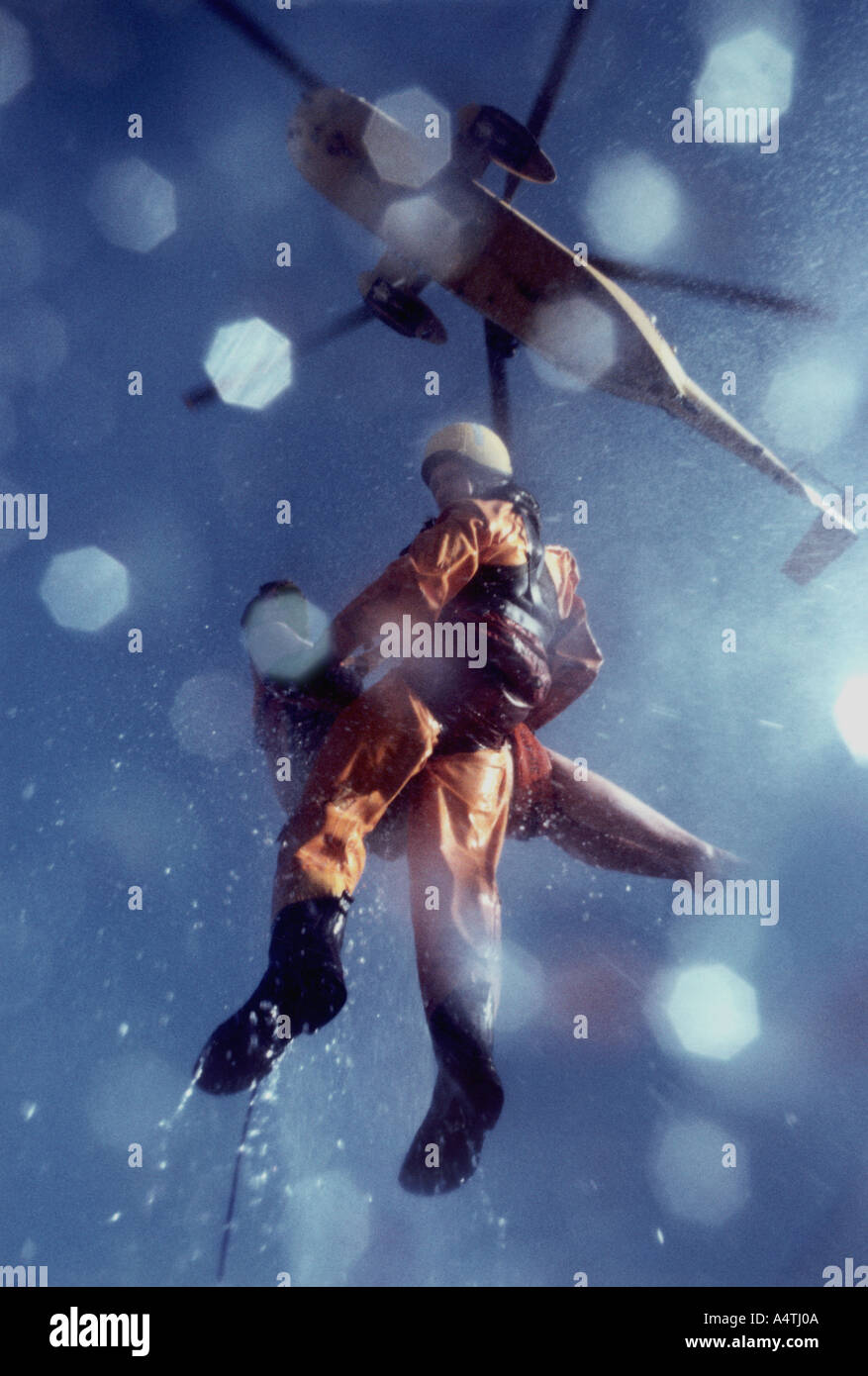 Air sea rescue with patient being winched up in to a helicopter Stock Photo