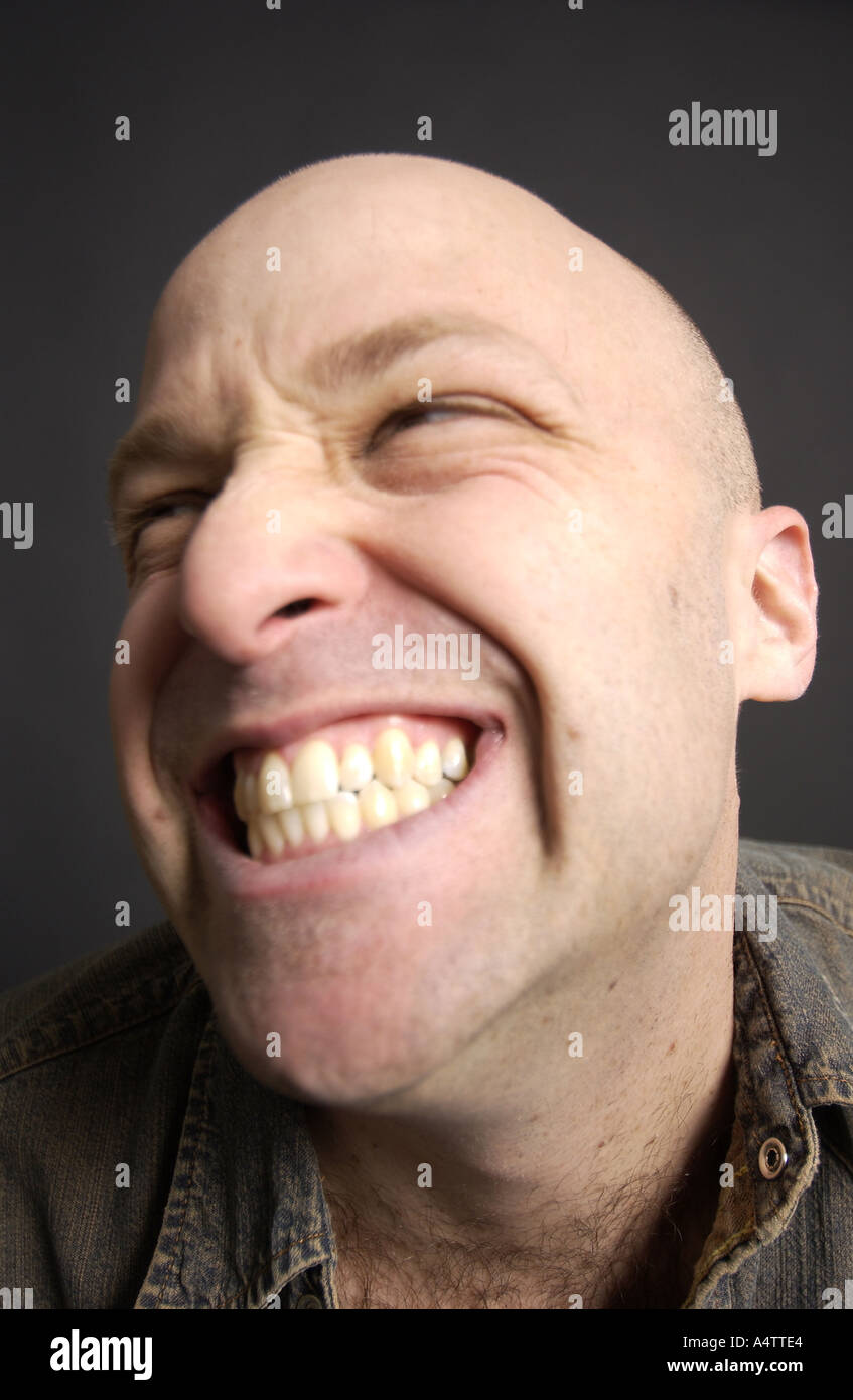Funny faces made by a funny looking bald young man. Grin and bear it Stock  Photo - Alamy