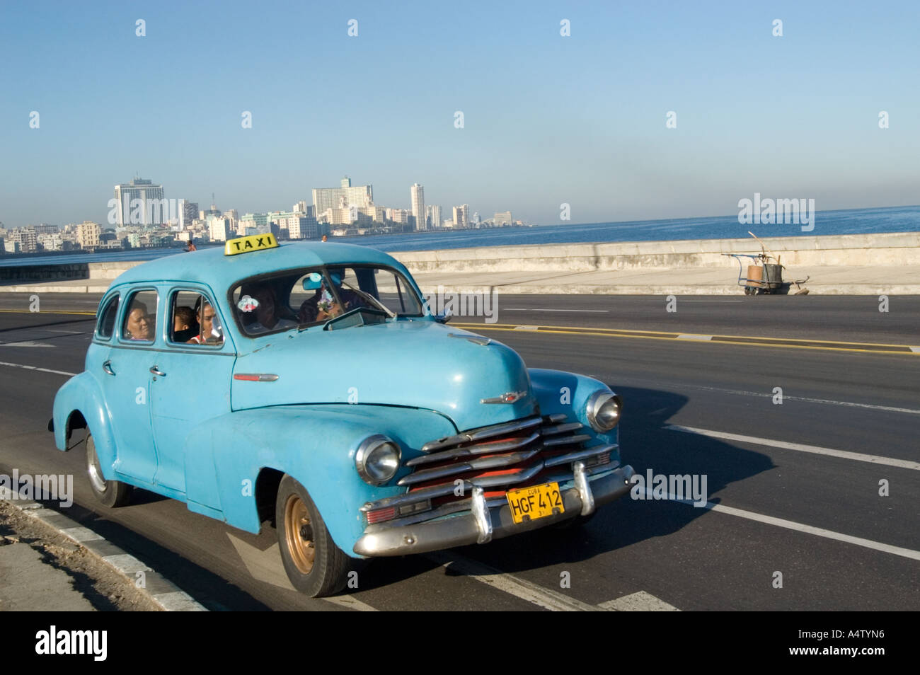 Taxi ride in a classic American car driving along El Malecon, Havana, Cuba Stock Photo