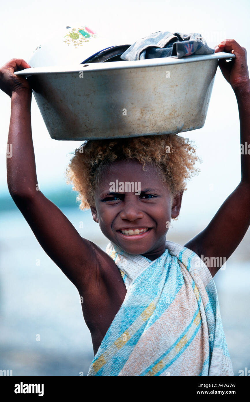 Valentina a young girl from Tembin village on the West Coast of New Ireland carries laundry to the river Stock Photo