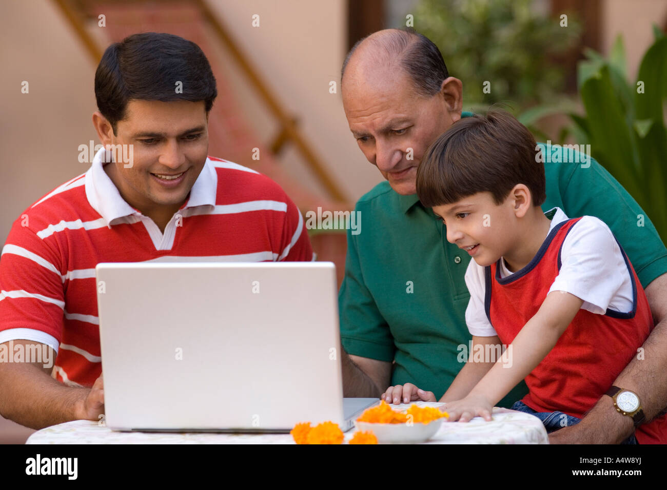 Three generations of men using laptop Stock Photo - Alamy