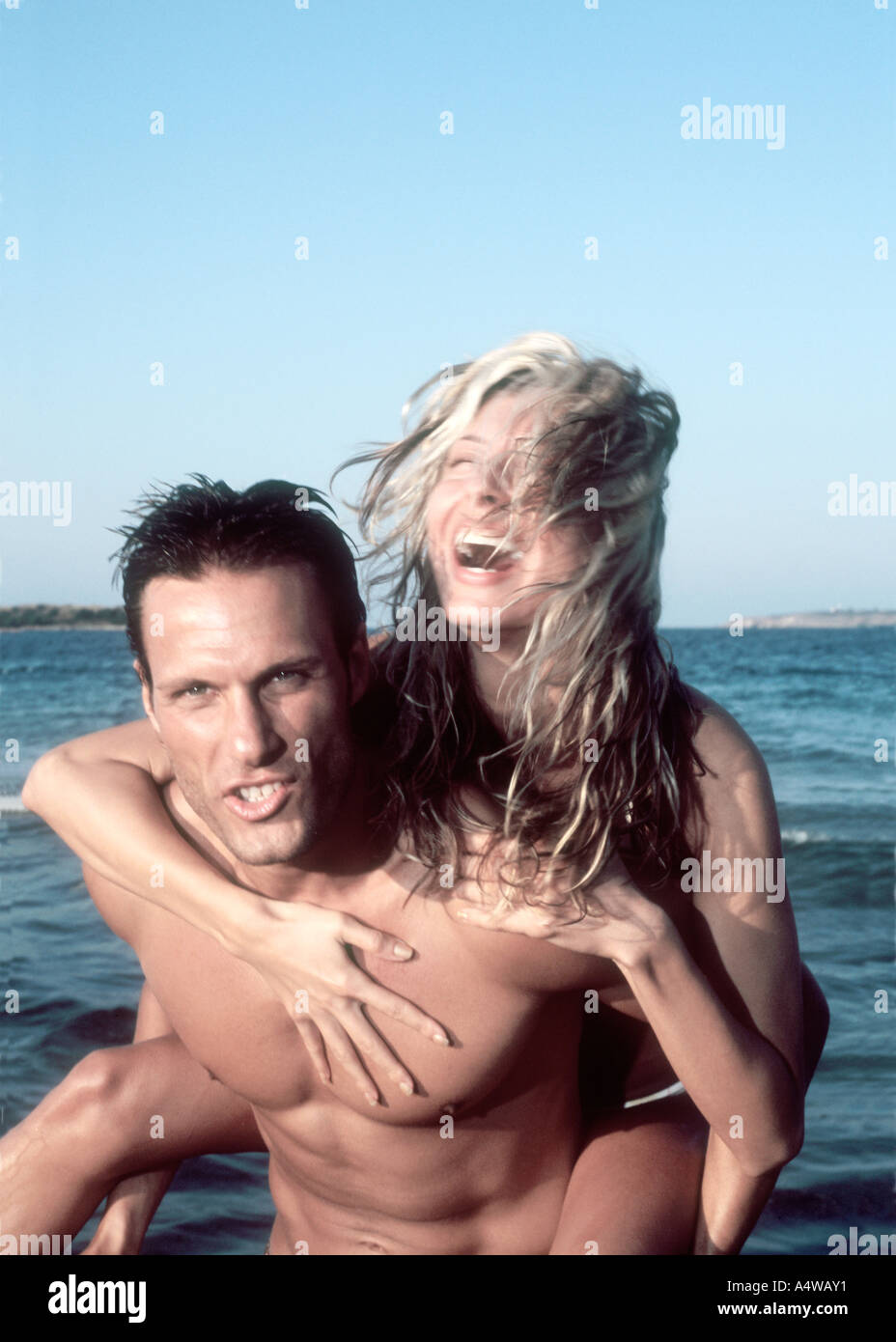 Young attractive couple amorously have fun on the beach. Stock Photo