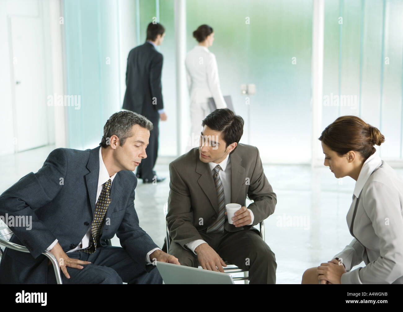 Business people sitting in lobby, having discussion Stock Photo