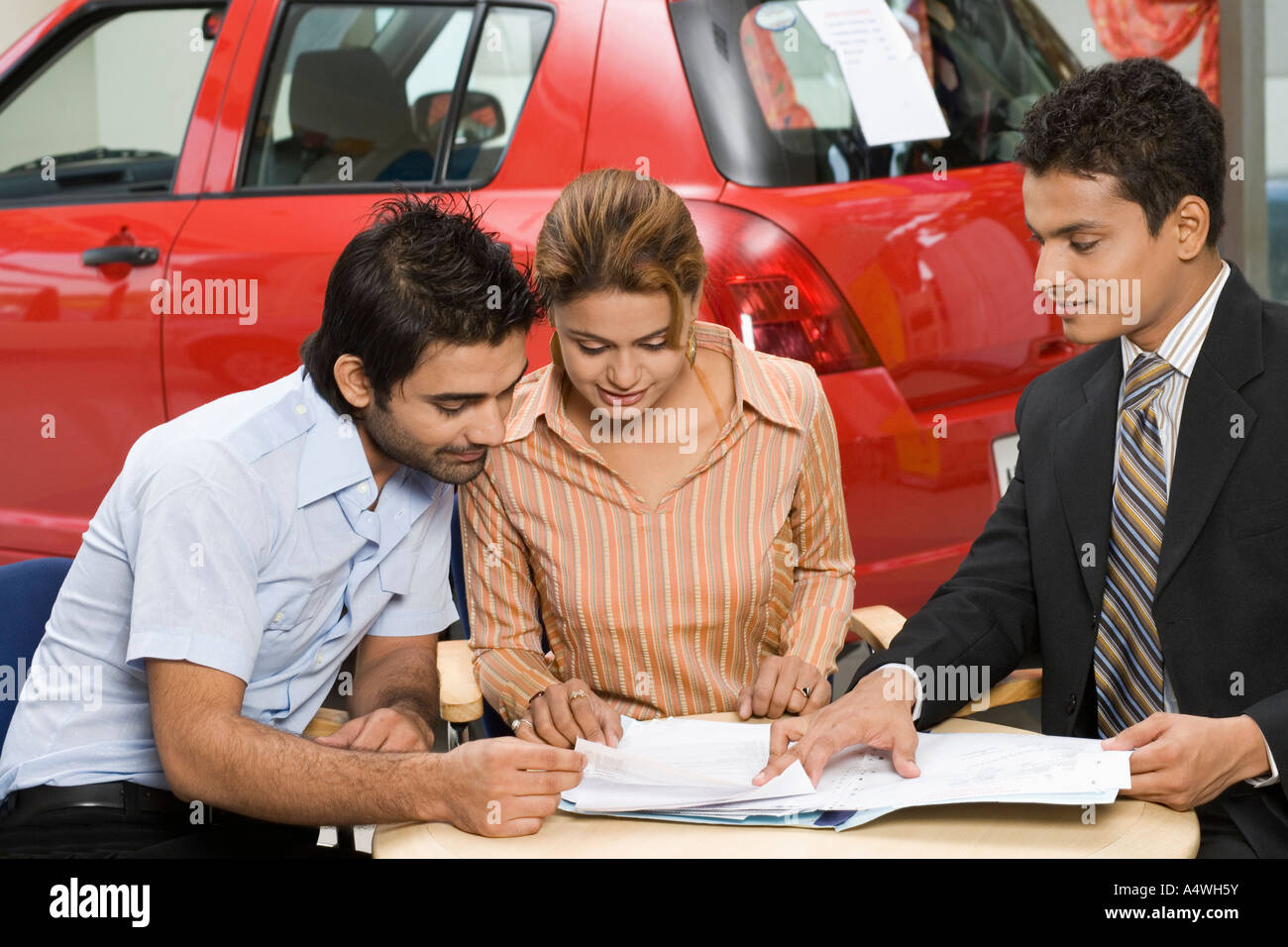 Couple signing papers to buy new car Stock Photo