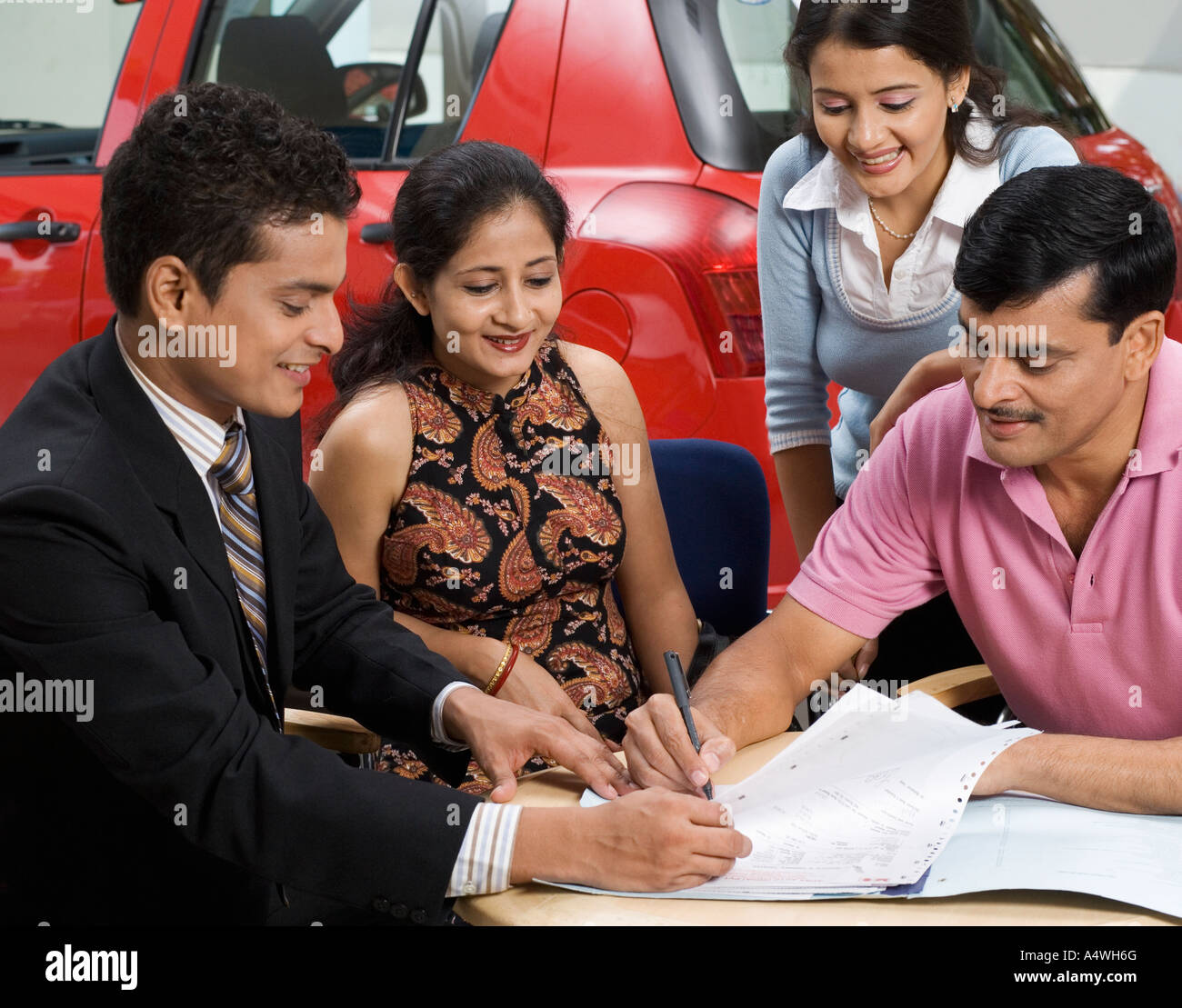 Family signing papers to buy new car Stock Photo