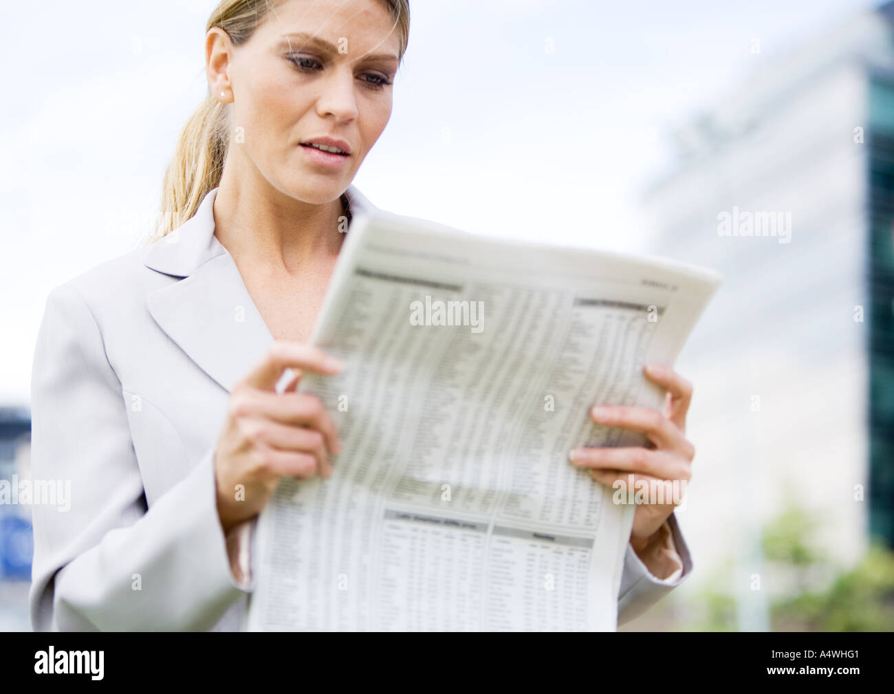 Businesswoman reading financial pages of newspaper Stock Photo - Alamy